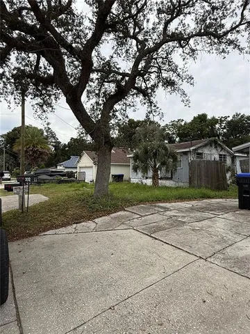 a front view of a house with a yard and trees
