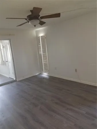 a view of a livingroom with wooden floor and a ceiling fan