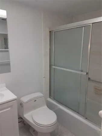 a white toilet sitting next to a shower