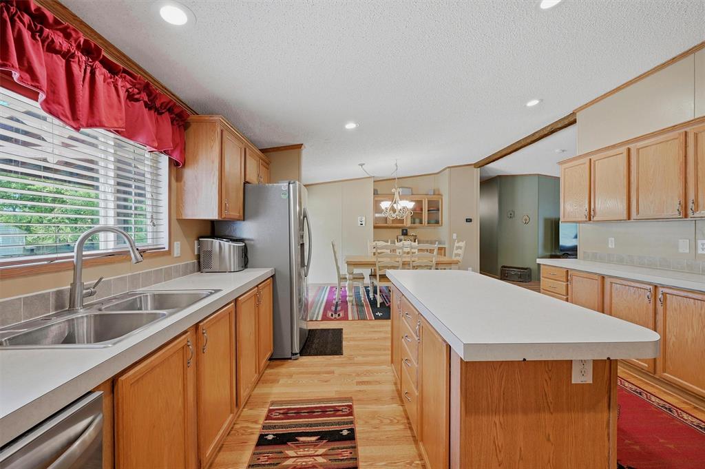 212 Sunset Road Pottsboro, TX 75076 - Photo 10 of 40 a kitchen with stainless steel appliances granite countertop a sink a stove and a refrigerator