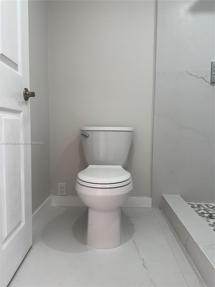 210 174th Street, Unit 1804 Sunny Isles Beach, FL 33160 - Photo 12 of 31 a white toilet sitting next to a bathroom sink