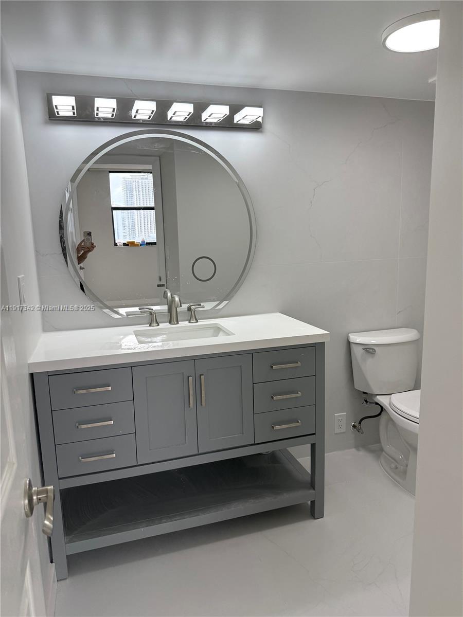 210 174th Street, Unit 1804 Sunny Isles Beach, FL 33160 - Photo 18 of 31 a bathroom with a toilet sink and mirror
