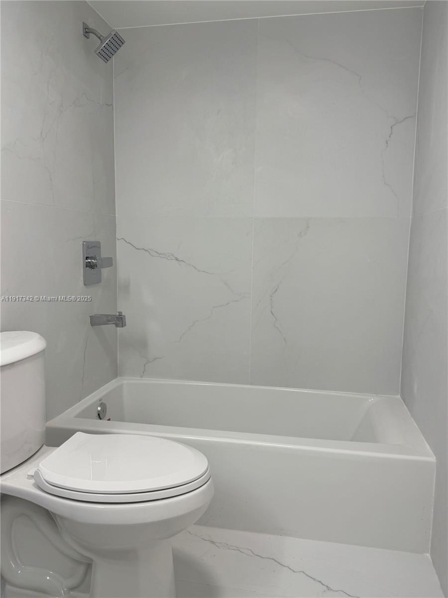 210 174th Street, Unit 1804 Sunny Isles Beach, FL 33160 - Photo 20 of 31 a bathroom with a toilet and a bath tub