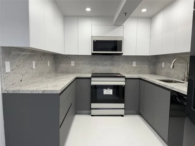 a kitchen with granite countertop cabinets sink and stove