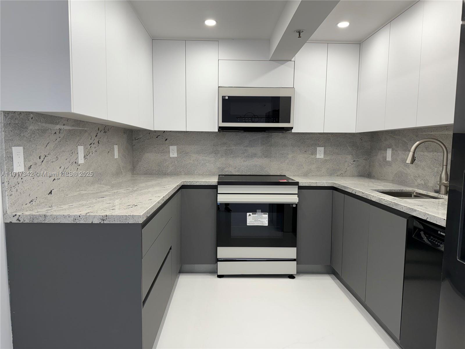 210 174th Street, Unit 1804 Sunny Isles Beach, FL 33160 - Photo 22 of 31 a kitchen with granite countertop a sink and a stove top oven