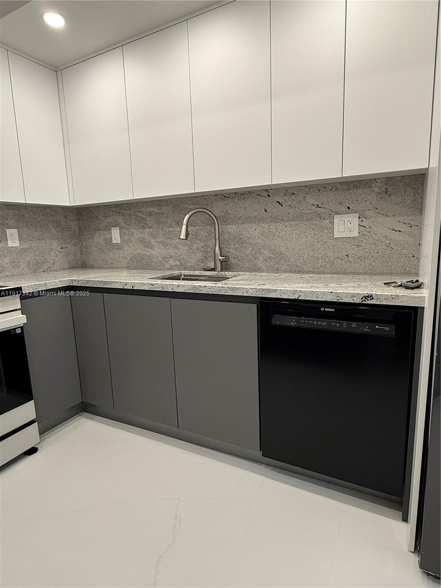 210 174th Street, Unit 1804 Sunny Isles Beach, FL 33160 - Photo 23 of 31 a kitchen with granite countertop cabinets sink and stove