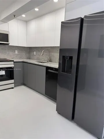 a kitchen with stainless steel appliances granite countertop a sink and a stove