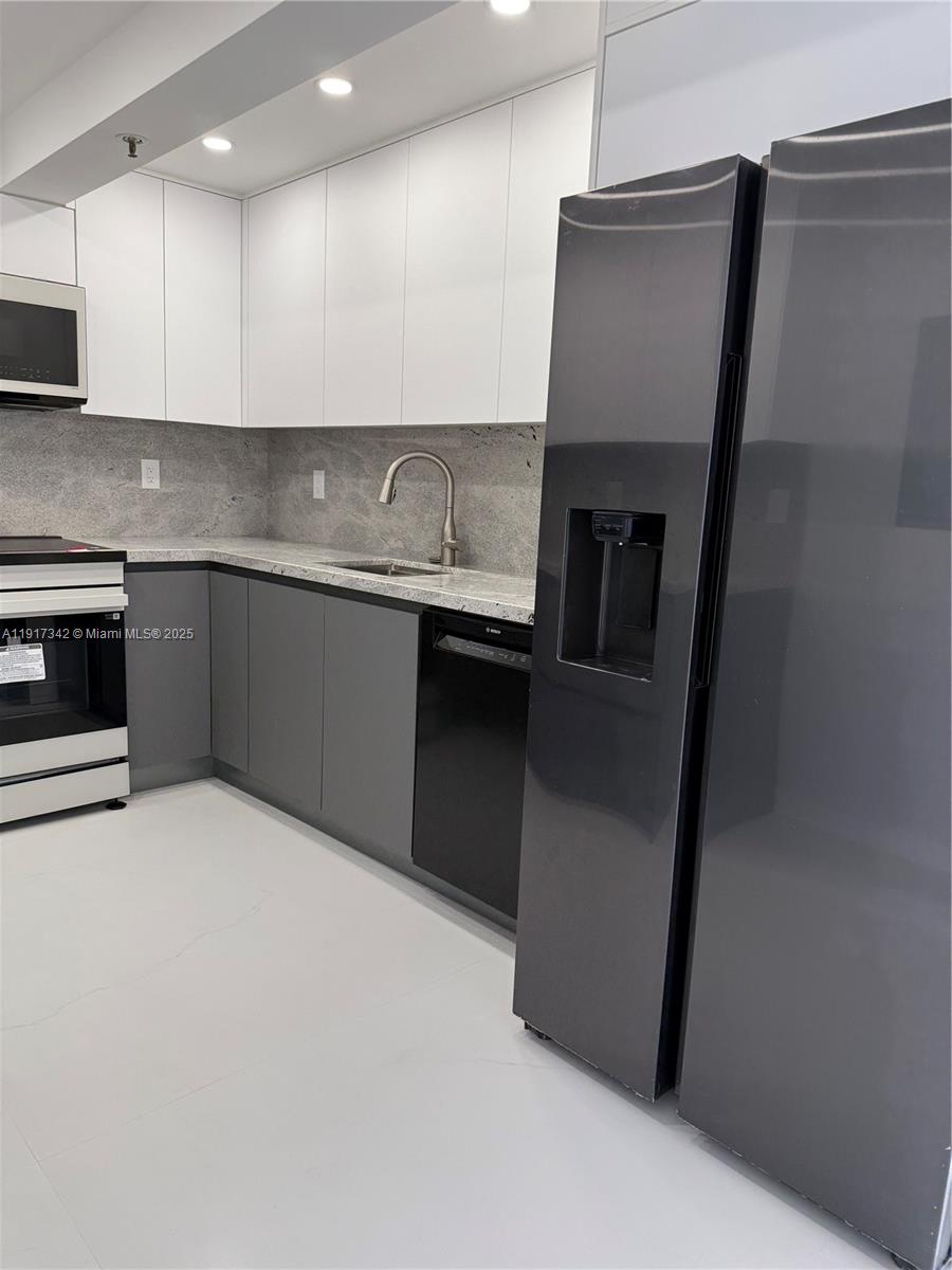 210 174th Street, Unit 1804 Sunny Isles Beach, FL 33160 - Photo 24 of 31 a kitchen with stainless steel appliances granite countertop a refrigerator a stove and a sink with wooden floor
