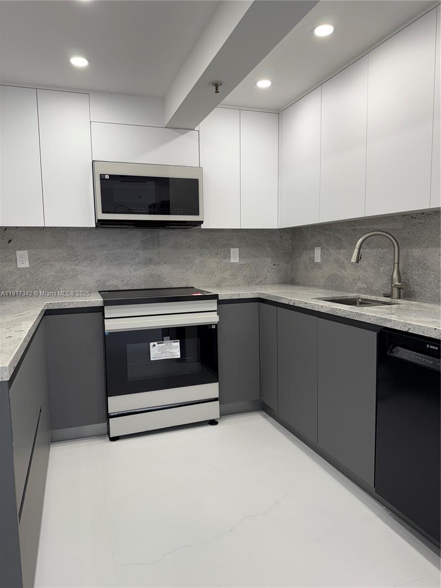 210 174th Street, Unit 1804 Sunny Isles Beach, FL 33160 - Photo 25 of 31 a kitchen with stainless steel appliances granite countertop a sink and a stove