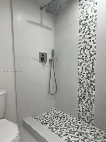 a bathroom with a toilet and a shower