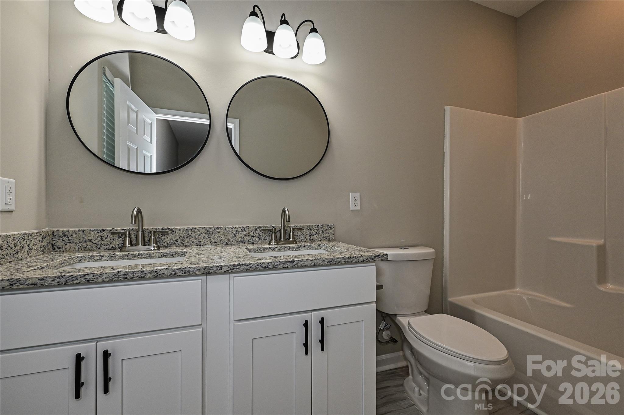 624 Harrison Street Rock Hill, SC 29730 - Photo 18 of 25 a bathroom with a granite countertop toilet a sink and a mirror