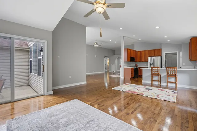 a large kitchen with stainless steel appliances kitchen island granite countertop a refrigerator and a sink