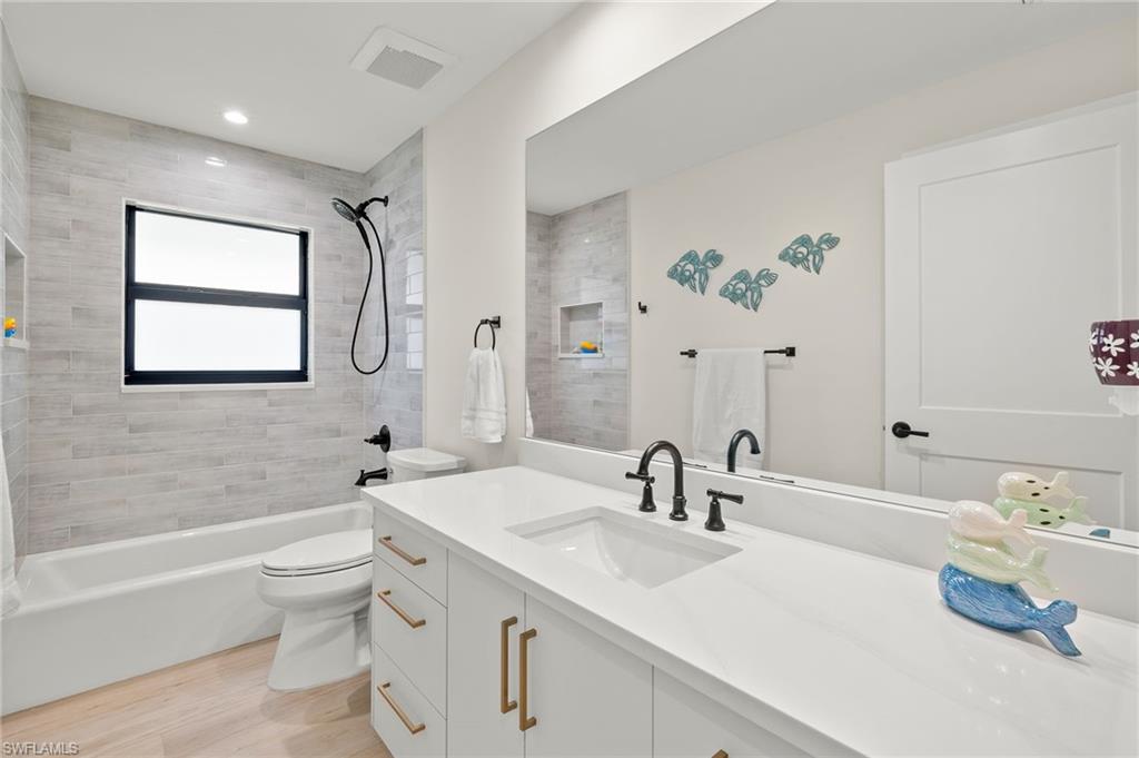 10274 Boca Circle Naples, FL 34109 - Photo 18 of 26 a bathroom with a sink a toilet and a bathtub