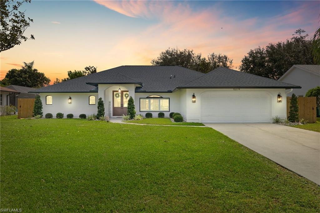 10274 Boca Circle Naples, FL 34109 - Photo 2 of 26 a front view of a house with a garden