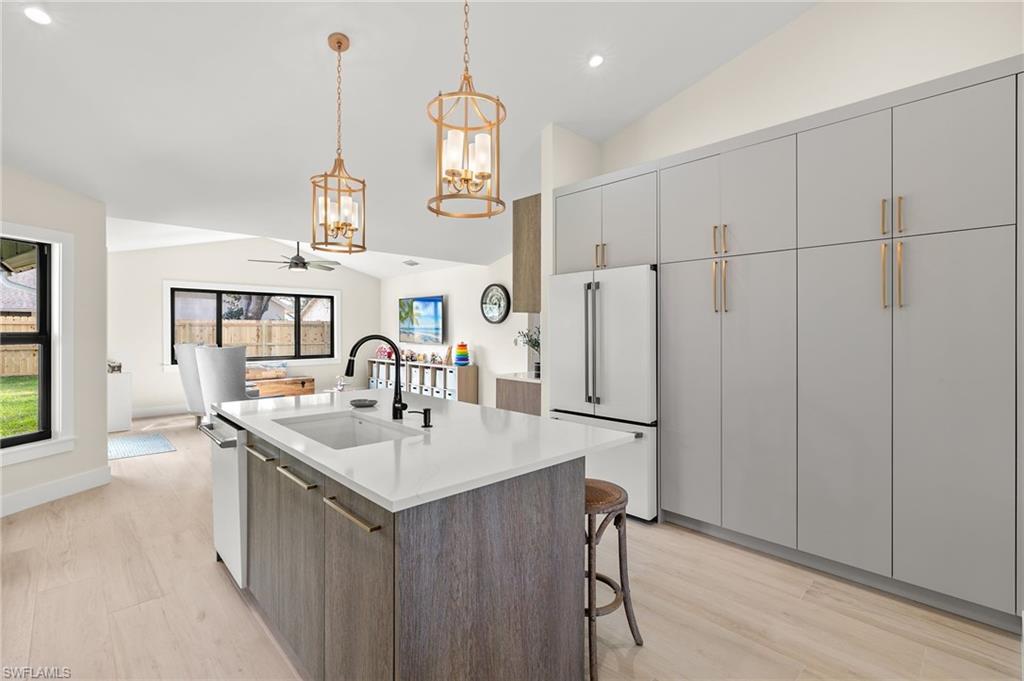 10274 Boca Circle Naples, FL 34109 - Photo 7 of 26 a kitchen with stainless steel appliances granite countertop a sink a center island and a wooden floor