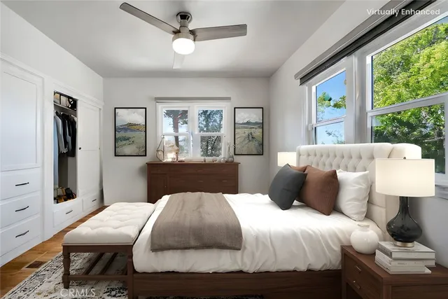 a bedroom with a large bed a chandelier and windows