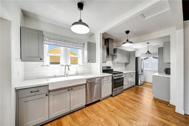 a kitchen with stainless steel appliances granite countertop a sink cabinets and wooden floor