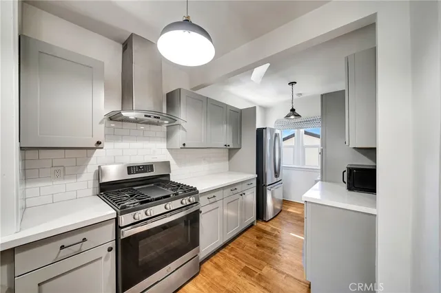 a kitchen with stainless steel appliances kitchen island a stove and a refrigerator