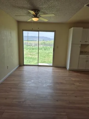 a view of a room with wooden floor and a window