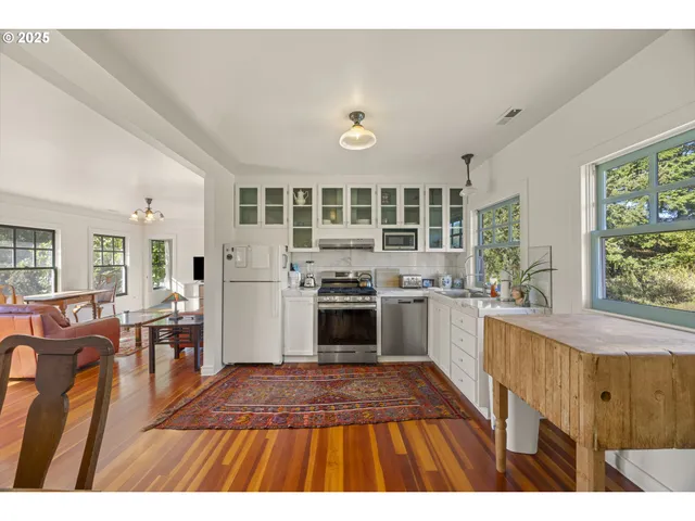 a open kitchen with stainless steel appliances granite countertop a stove a sink dishwasher and cabinets with wooden floor