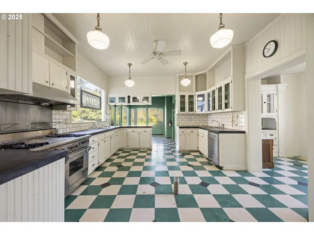 a kitchen with a checkered floor and white cabinets