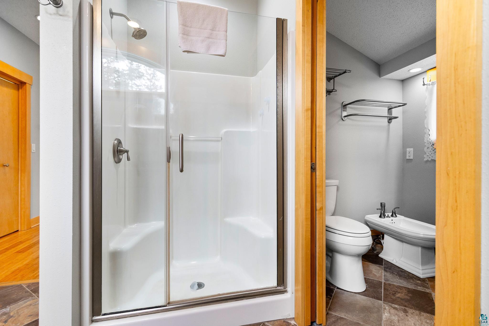 5163 Greenwood Road Duluth, MN 55804 - Photo 21 of 47 Enclosed shower with built-in seating, brushed nickel fixtures, and clear glass doors