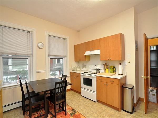 12 Kilsyth Road, Unit 1 Brookline, MA 02445 - Photo 7 of 9 a kitchen with a table chairs refrigerator and cabinets