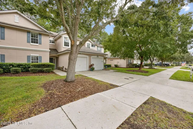 a front view of a house with a yard and trees