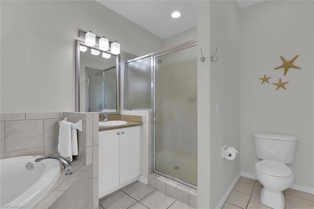 7925 Mahogany Run Lane, Unit 924 Naples, FL 34113 - Photo 21 of 40 a bathroom with a granite countertop sink toilet and shower