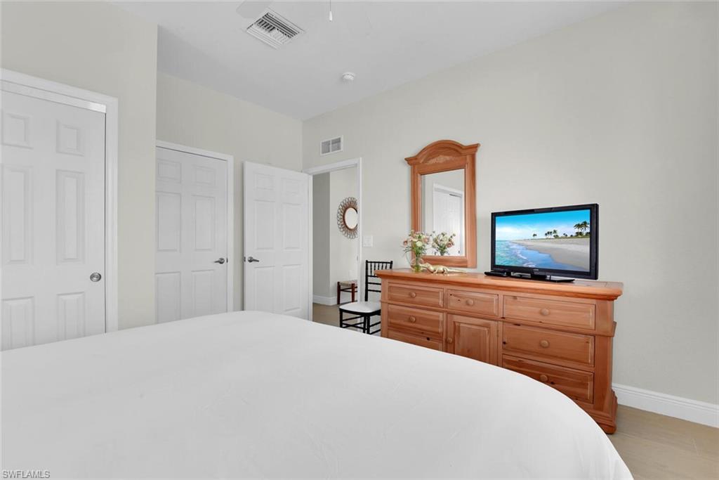 7925 Mahogany Run Lane, Unit 924 Naples, FL 34113 - Photo 24 of 40 a bedroom with a bed and a flat screen tv
