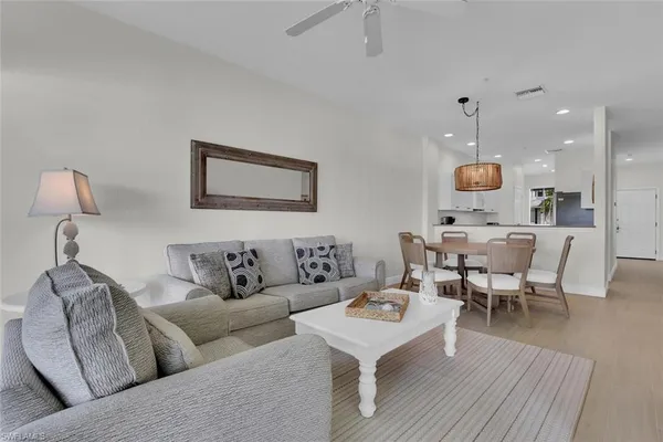 a living room with couches kitchen view and kitchen view