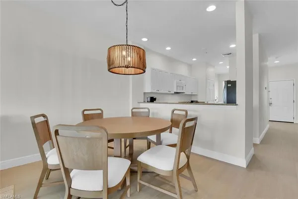a view of a dining room with furniture a chandelier and wooden floor