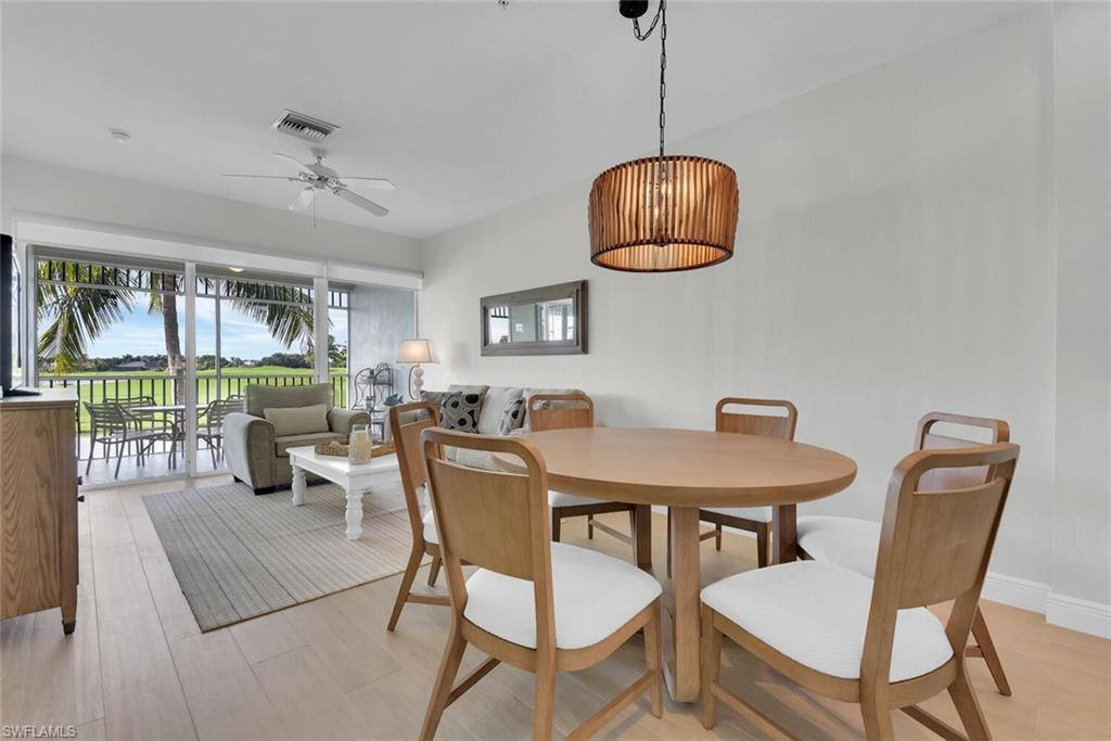 7925 Mahogany Run Lane, Unit 924 Naples, FL 34113 - Photo 9 of 40 a dining room with wooden floor a chandelier a glass table and chairs