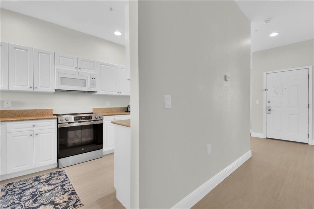 7925 Mahogany Run Lane, Unit 924 Naples, FL 34113 - Photo 10 of 40 a kitchen with granite countertop white cabinets and stainless steel appliances