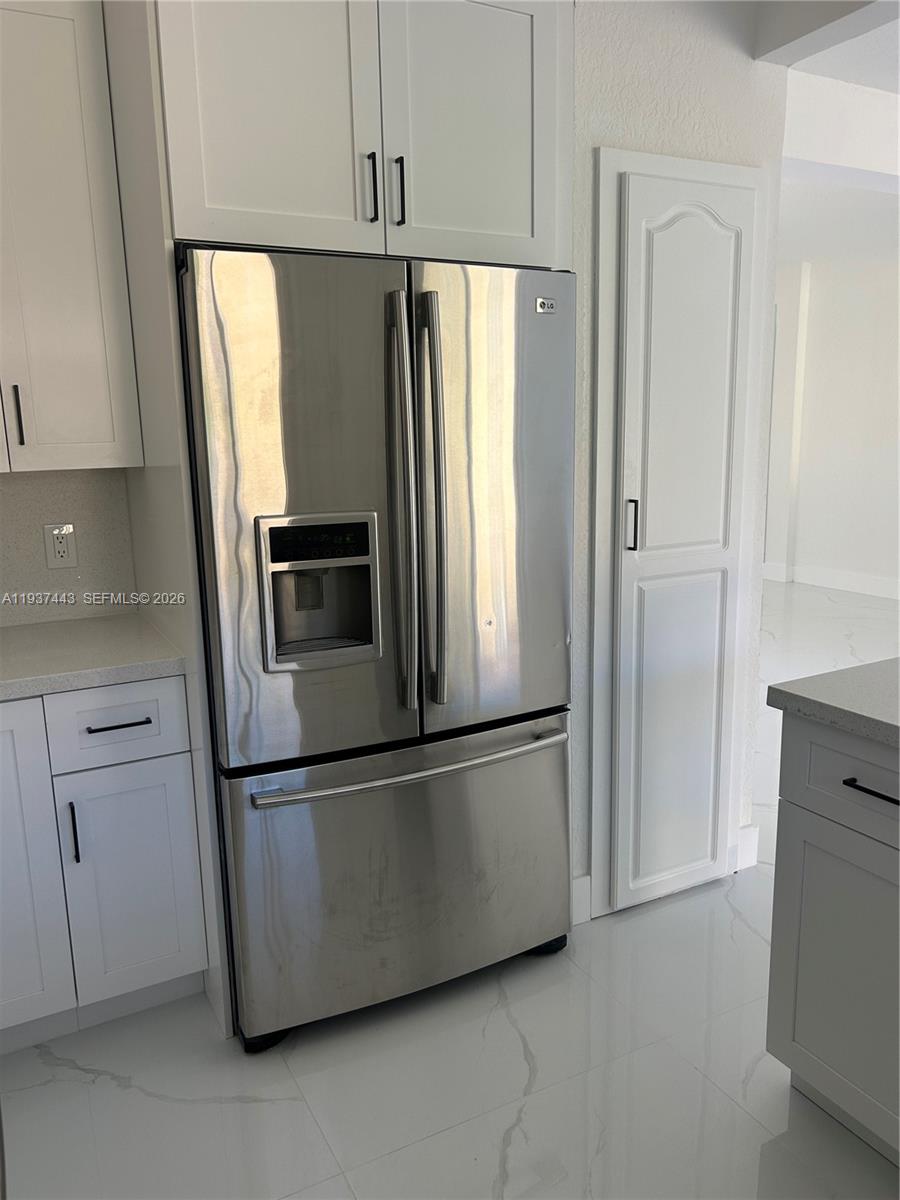7729 Northwest 194th Terrace Hialeah, FL 33015 - Photo 15 of 21 a metallic refrigerator freezer sitting in a kitchen