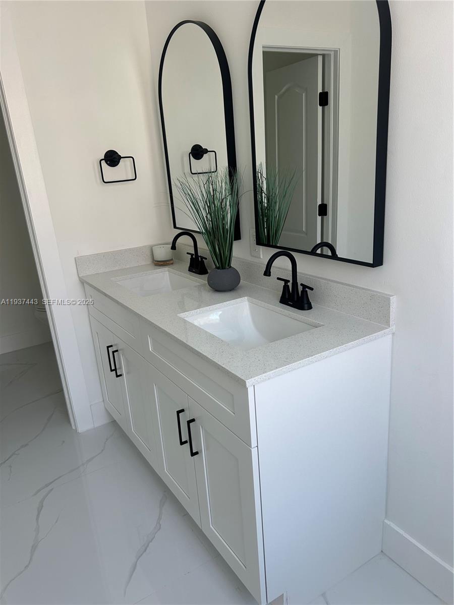 7729 Northwest 194th Terrace Hialeah, FL 33015 - Photo 17 of 21 a bathroom with a sink and a mirror