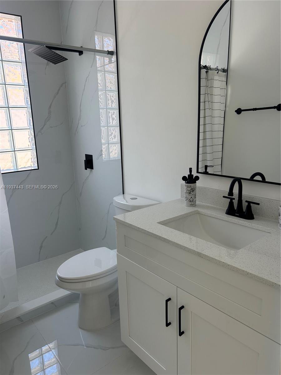 7729 Northwest 194th Terrace Hialeah, FL 33015 - Photo 18 of 21 a bathroom with a sink a toilet and a mirror