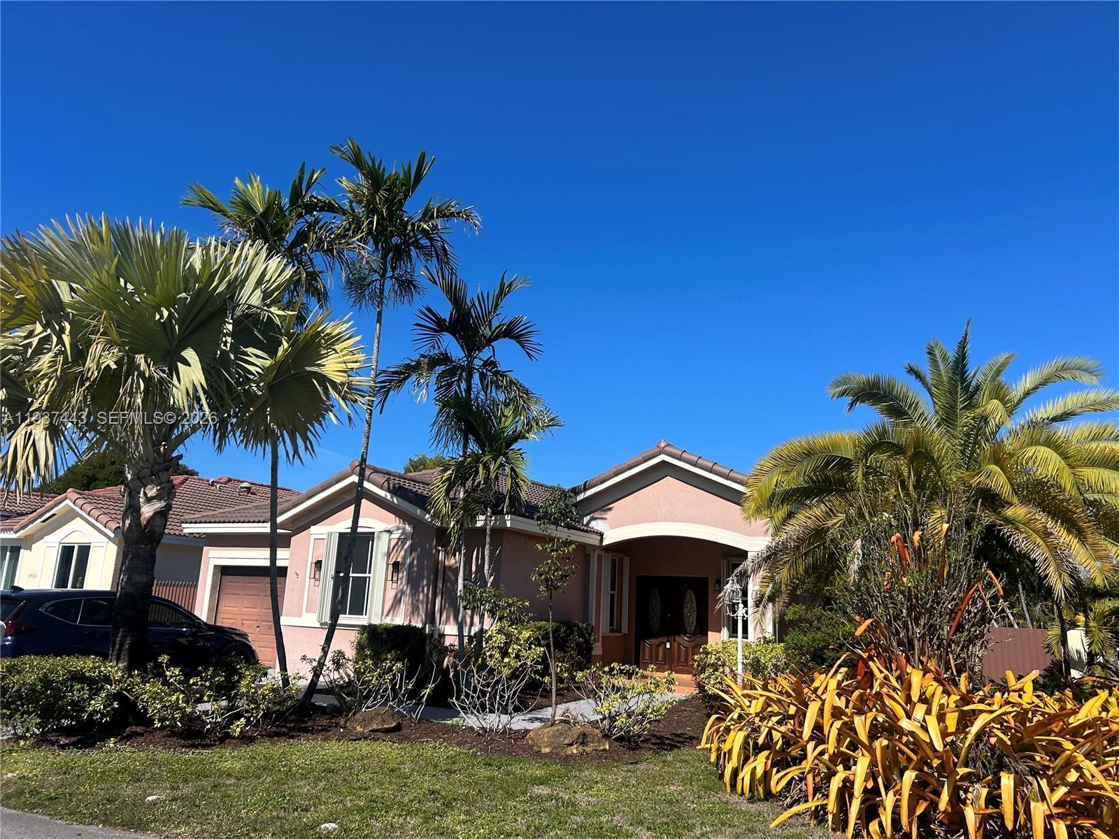 7729 Northwest 194th Terrace Hialeah, FL 33015 - Photo 2 of 21 a front view of a house with garden