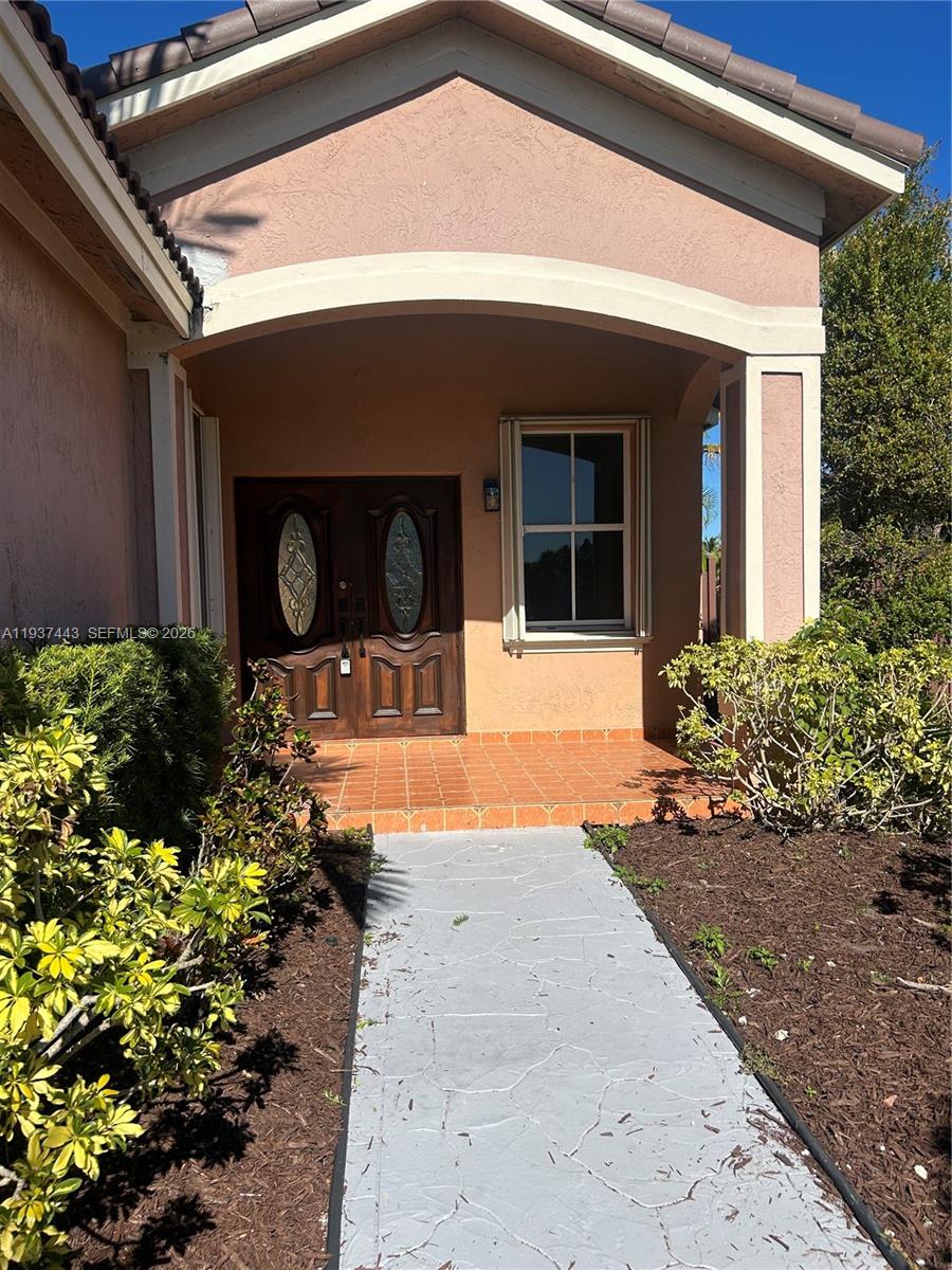 7729 Northwest 194th Terrace Hialeah, FL 33015 - Photo 3 of 21 a front view of a house with a yard