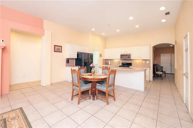 a living room with furniture a flat screen tv and a chandelier
