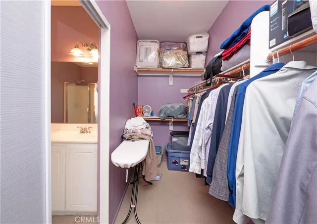 a view of walk in closet with clothes and shoes