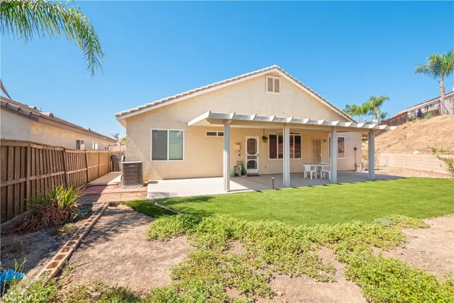a view of a house with a yard and potted plants