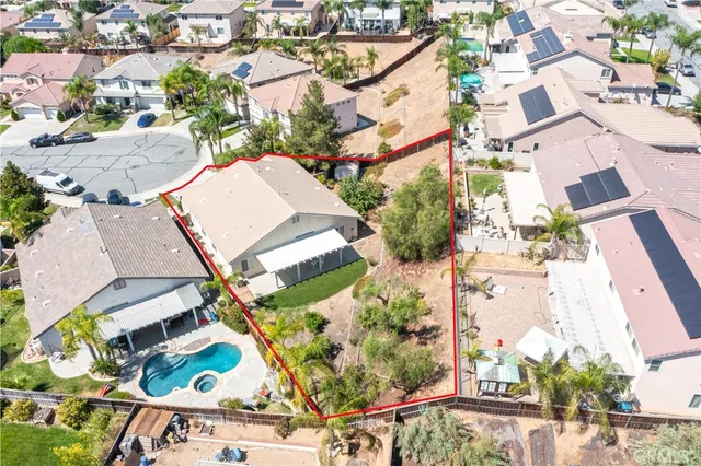 an aerial view of a house with a yard and a large tree