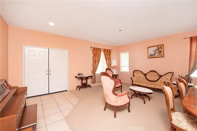a living room with furniture and a dining table with garden view