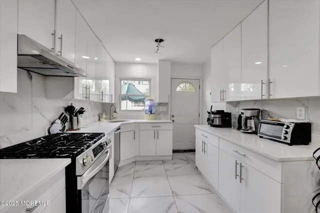 a kitchen with stainless steel appliances a sink stove and cabinets