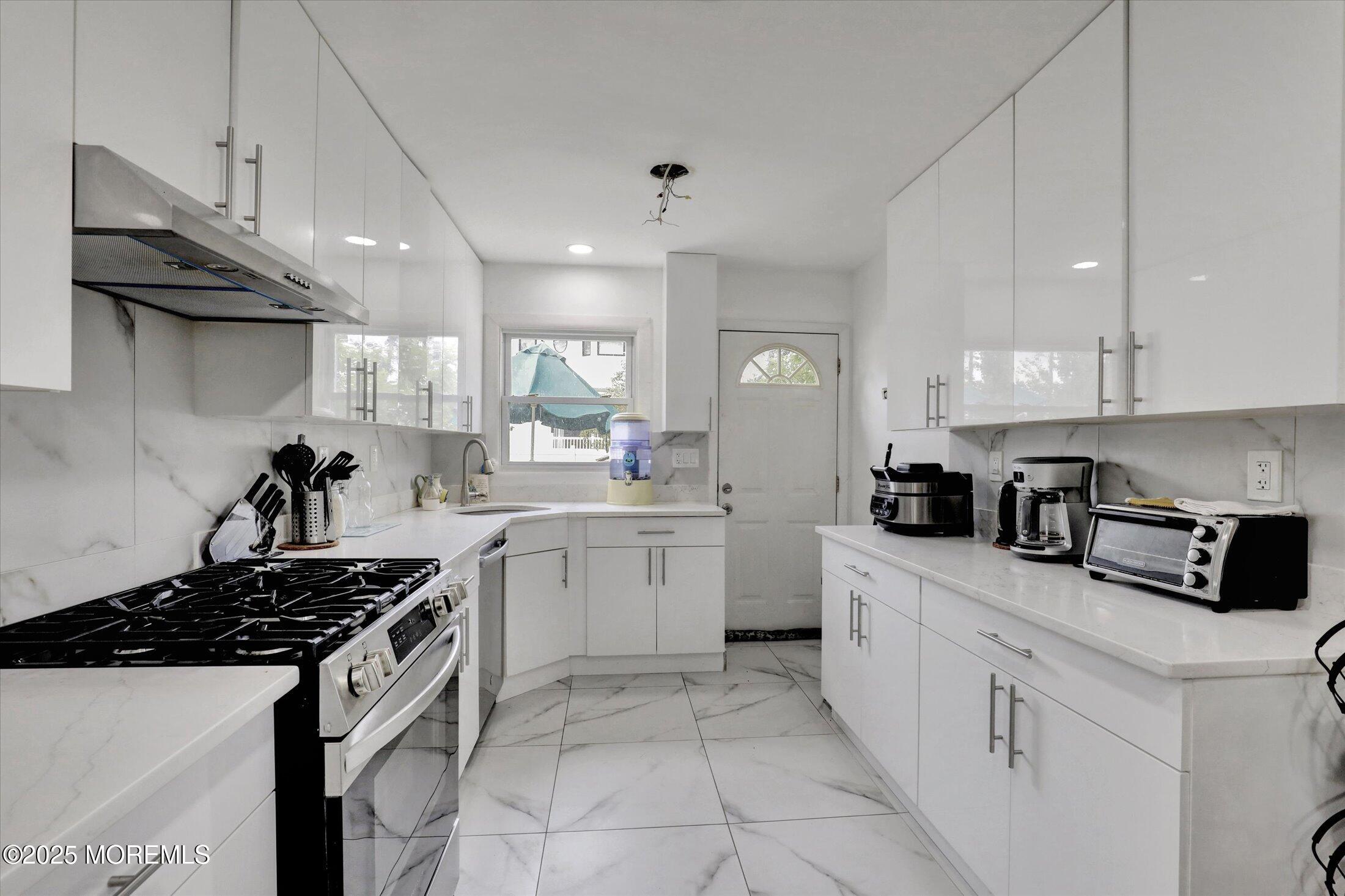 24 Berger Avenue Oakhurst, NJ 07755 - Photo 16 of 49 a kitchen with stainless steel appliances a sink stove and cabinets