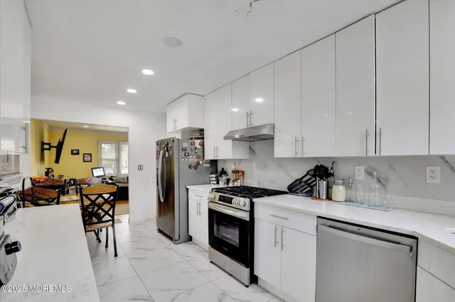 a kitchen that has a lot of cabinets a sink and appliances in it