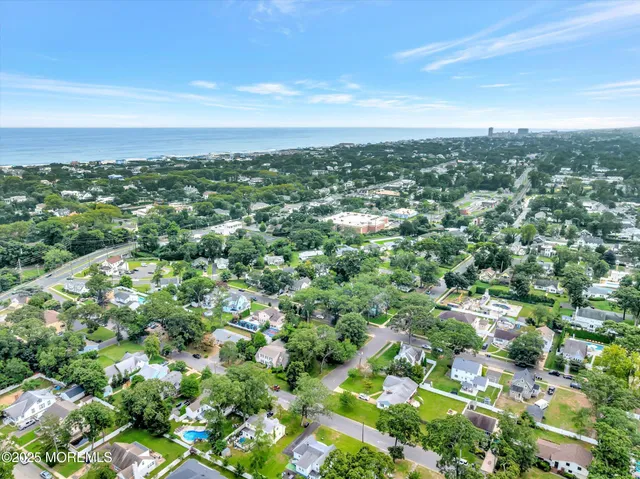 an aerial view of residential houses with outdoor space and trees