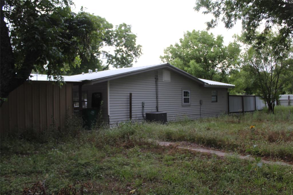 510 Hamby Road Clyde, TX 79510 - Photo 3 of 23 Single-story residence featuring light-colored siding, a white metal roof, and multiple windows