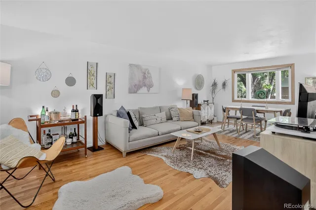 a living room with furniture a flat screen tv and a table